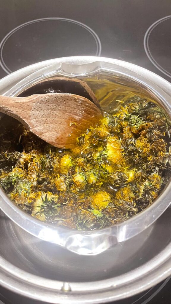 Dandelion flowers and oil in a double boiler