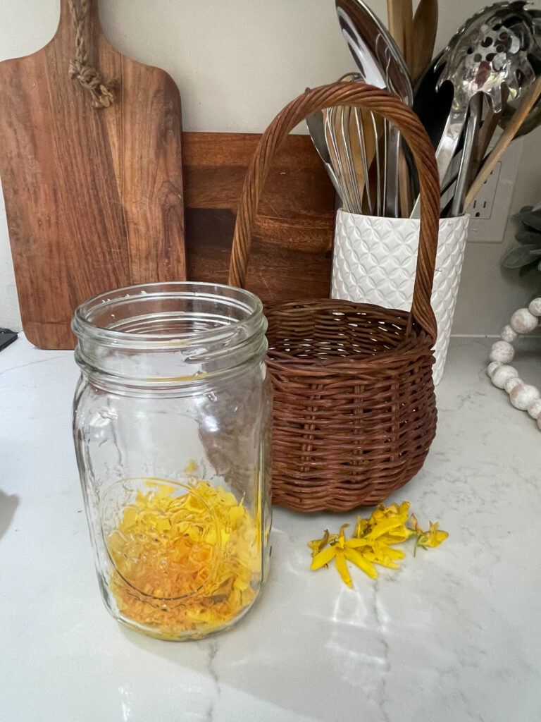 forsythia flowers in a mason jar next to basket
